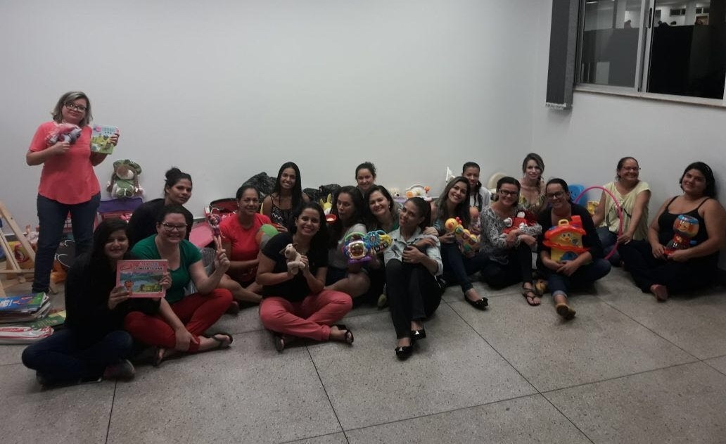 Professora Alciane (segunda da direita para a esquerda no primeiro plano) com alunas do curso de Pedagogia Bilíngue e os materiais arrecadados para a Brinquedoteca e Laboratório de Ensino no Câmpus Aparecida de Goiânia do IFG